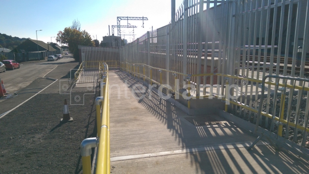 Train station featuring a disabled access ramp with handrails made from Interclamp Key Clamp DDA Assist fittings and safety yellow powder-coated tubes, enhancing accessibility for all